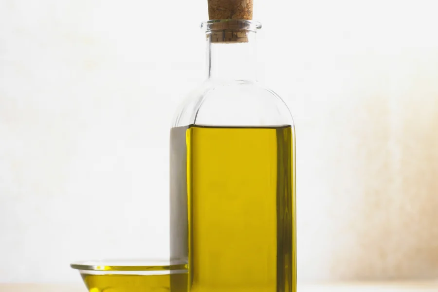 Ελαιόλαδο σε γυάλινο μπουκάλι και μικρό μπολ — θεματική φωτογραφία